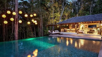 Pool and guest bungalows at dusk at a luxury property in Trancoso, Bahia